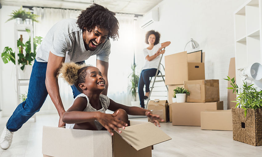 Family smiling with moving boxes