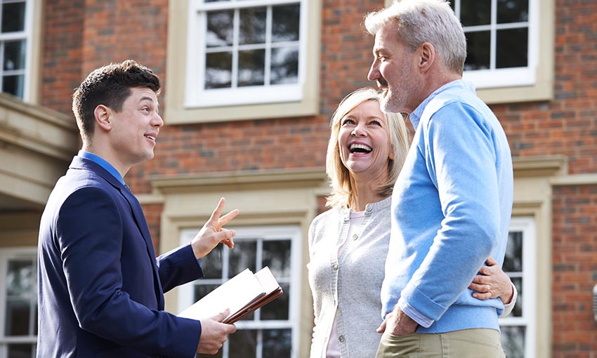 Older couple talking to a realtor with paperwork