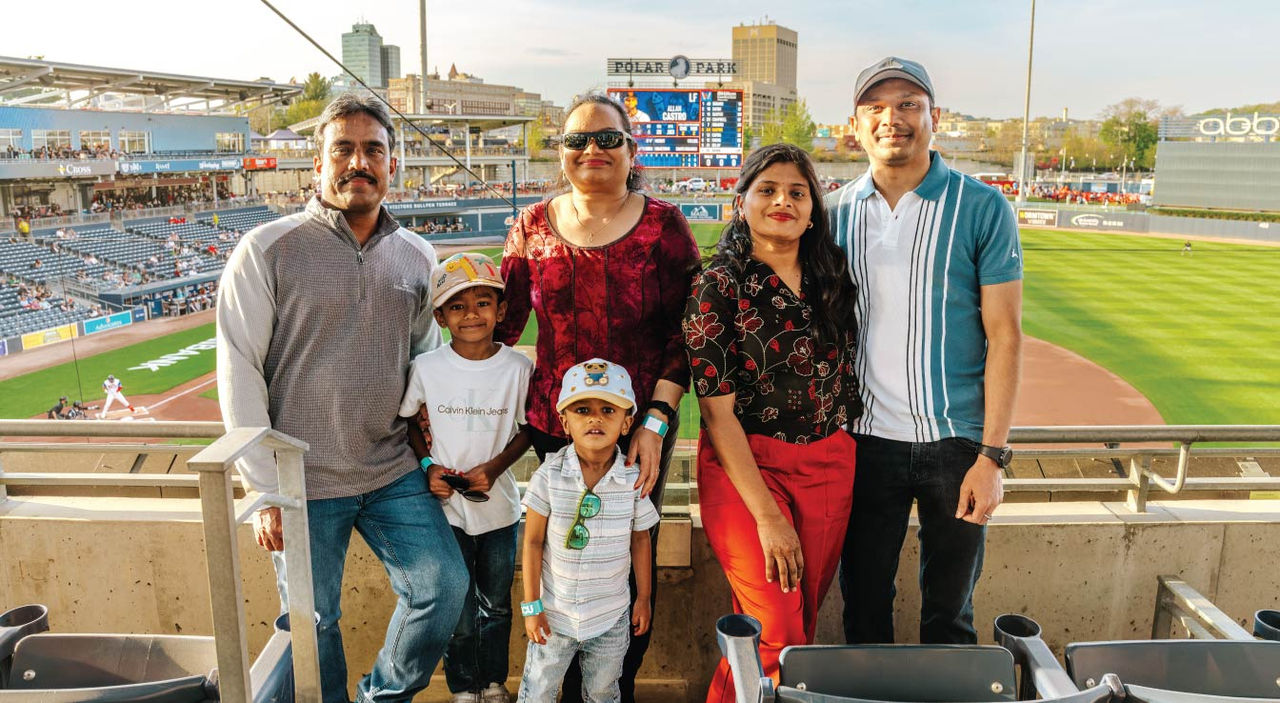 A family posing together in stadium seating overlooking a baseball field at Polar Park