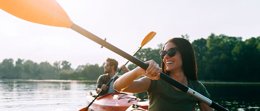 A couple smiling kayaking.