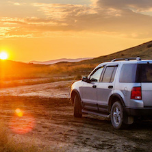 Car driving into sunset