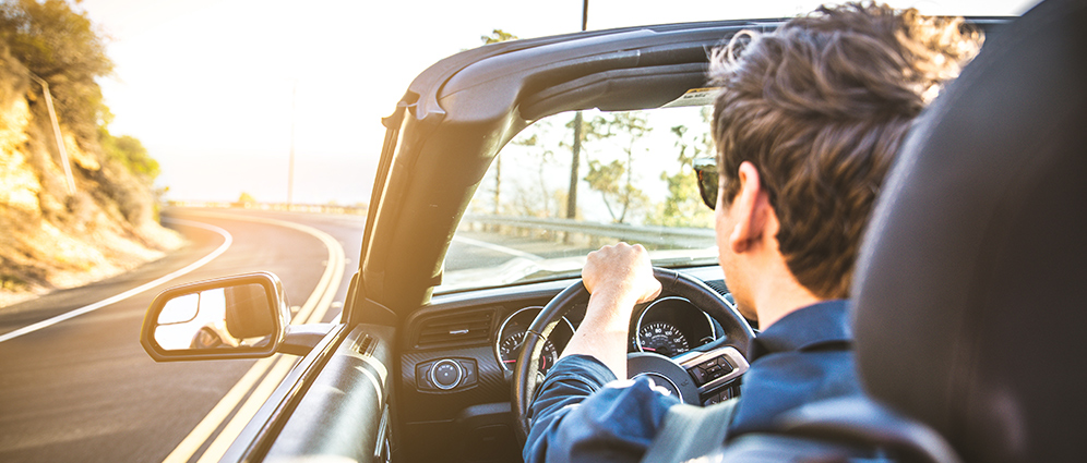 Man driving convertible car