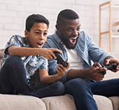 Man and son playing video game with online subscription.