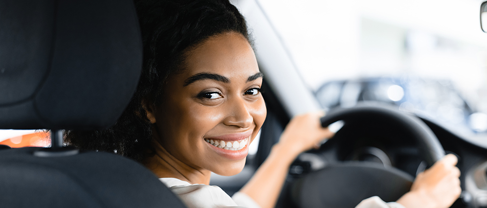 Woman smiling looking back inside of a car