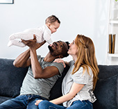 Young couple holding baby and smiling