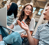 Young students sitting together with laptops studying