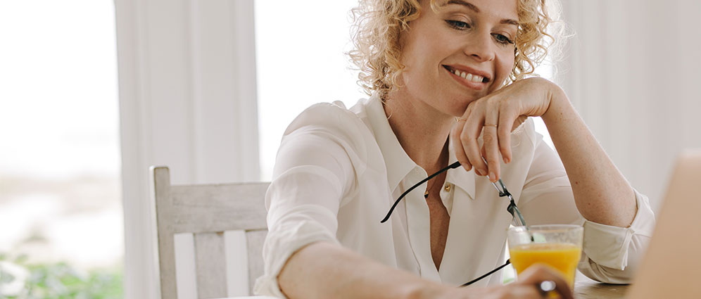 Woman looking at her computer with a smile. 