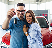 Husband and wife holding keys to new car
