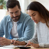 Couple looking at calculator and bills