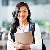 Young, college-aged woman holding notebook and backpack