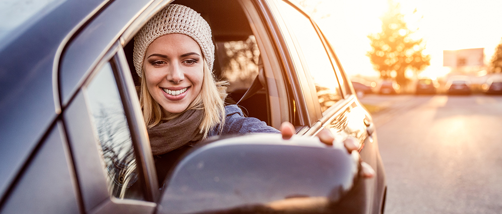 Woman smiling adjusting rearview mirror