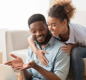 Man and woman sitting, looking at laptop and talking