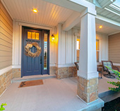 Front door to house with porch sitting area