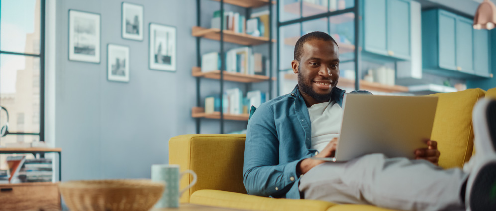 A man sitting on the couch on his laptop.