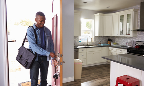 African american man walking into him home smiling