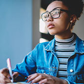 Student looking ahead while writing in a notebook