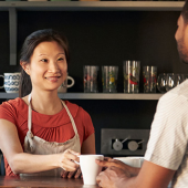 Woman smiling taking credit card from male customer