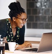 A woman smiling at her computer.