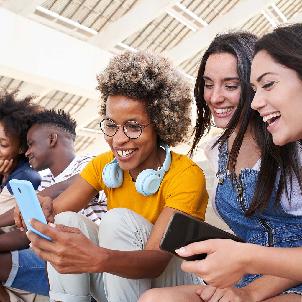 group of gen-z people looking at one phone