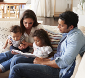 Family sitting together reading a book