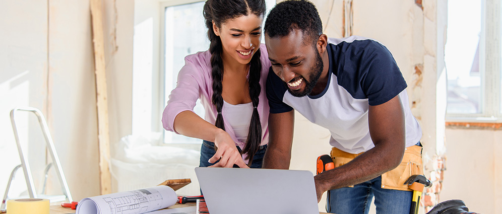 Man and woman smiling looking at a laptop