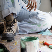 Man sitting near paint supplies
