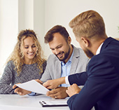 Man and woman sitting at table with mortgage loan officer