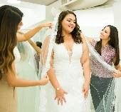 Woman trying on wedding dress with friends