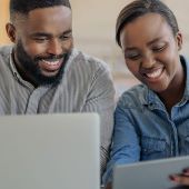 A woman smiling looking at her computer.