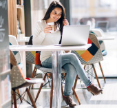 A woman drinking coffee with her laptop.