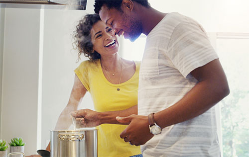 happy African American couple cooking in the kitchen