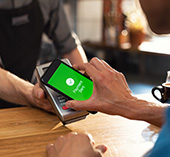 Person paying at coffee shop with their mobile wallet