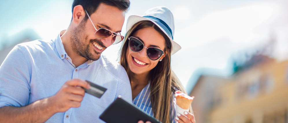 Man and woman paying for their bill with a credit card while travelling on vacation.