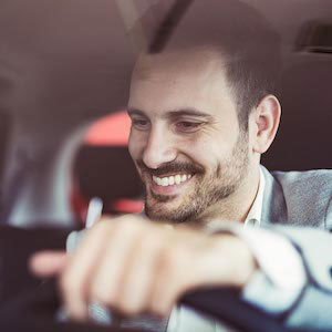Man driving with a smile on his face.