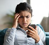 Woman looking at her phone concerned 
