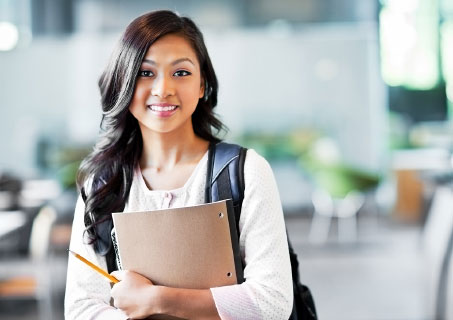 Young, college-aged woman holding notebook and backpack