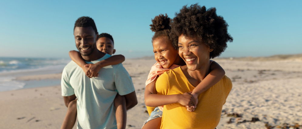 Parents and children smiling, standing on the beach on vacation