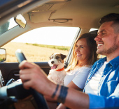 Man, woman, and their dog riding in a car