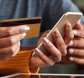 Woman holding phone, using her credit card online