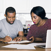 African American couple looking at bills