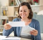 Woman smiling holding tax refund check