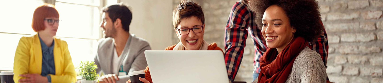 A group of people around a laptop looking at DCU Online Deposit options