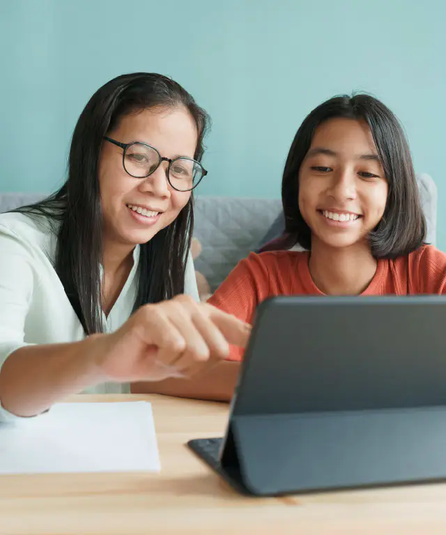 Mother and daughter viewing their DCU Greenlight account on a tablet