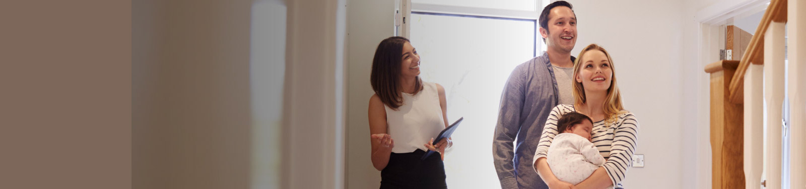Couple with baby viewing a new home with a Realtor