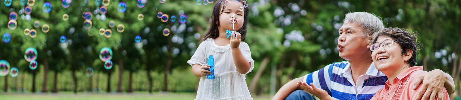 Granddaughter blowing bubbles with grandparents