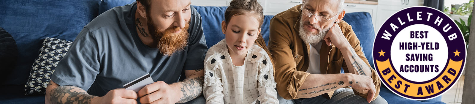 Father holding a credit card next to his daughter and grandfather while looking at a computer screen.