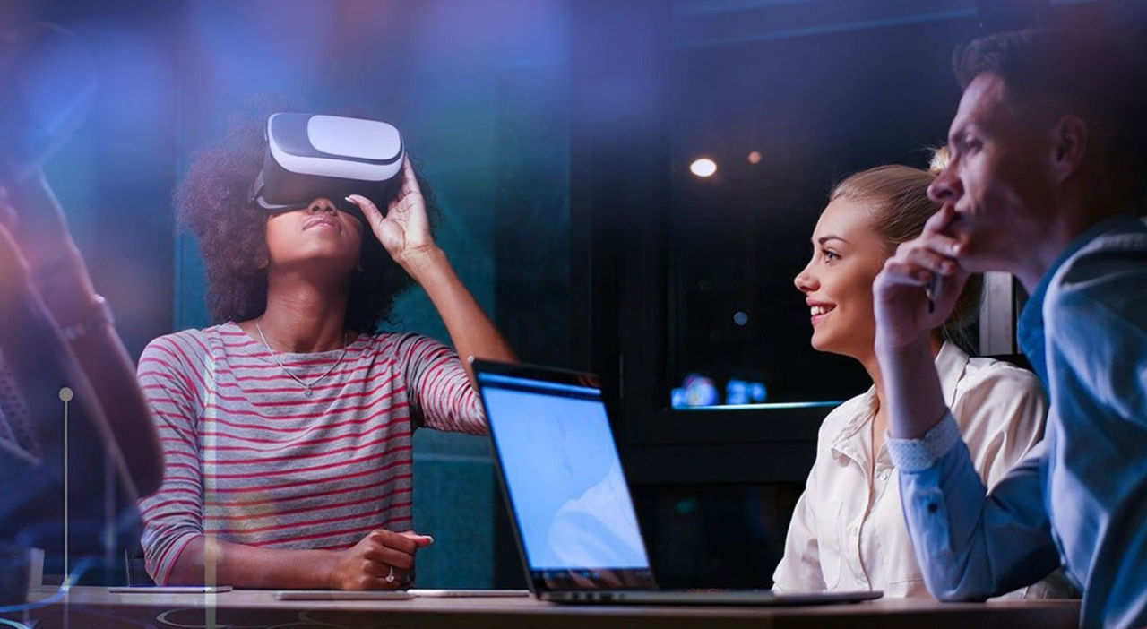 Image of young people around a table and looking into a VR viewer.
