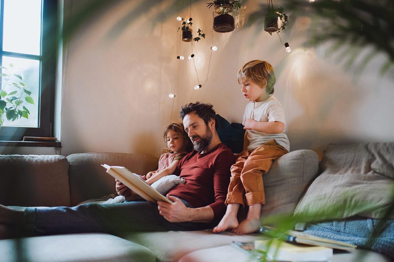 Father reading to his children at home