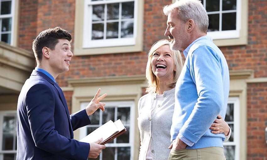 older couple talking to a man with paperwork