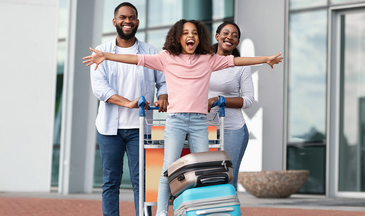 Parents with child and a cart full of suitcases